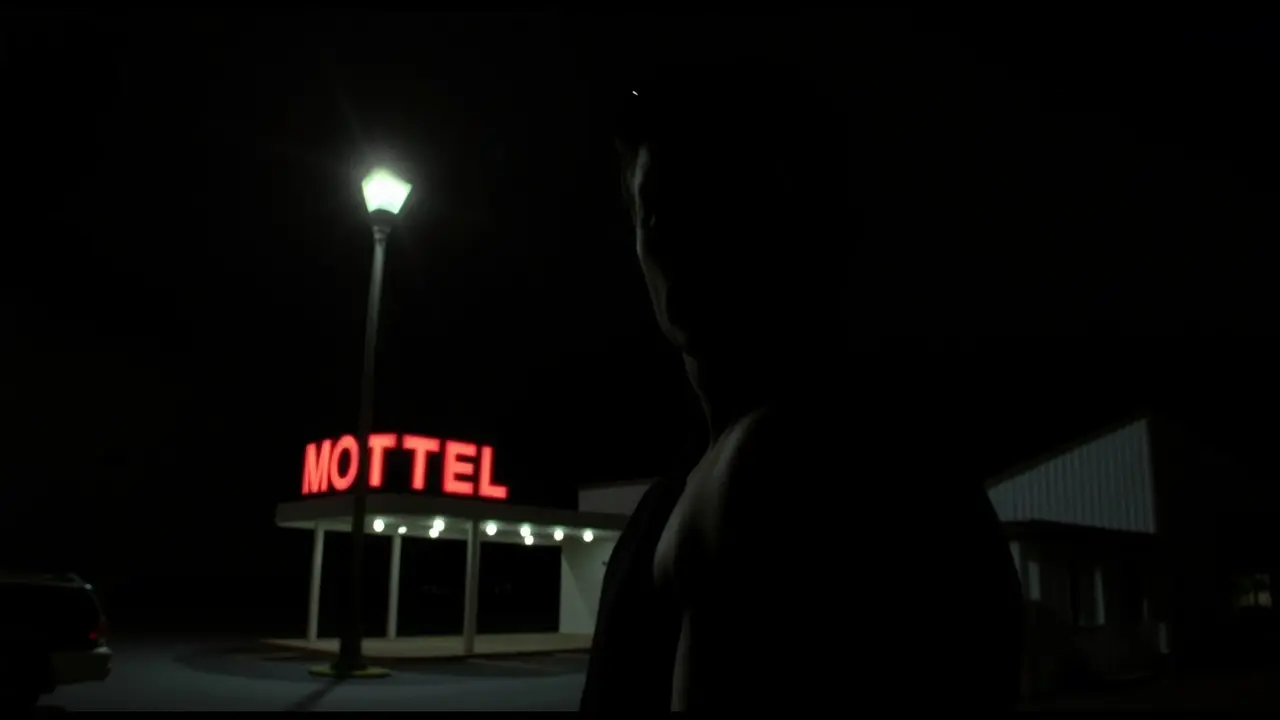 Homem misterioso olhando para motel à noite