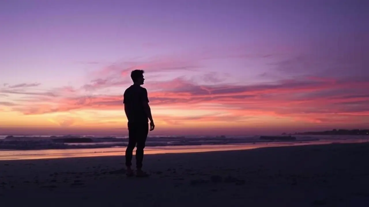 Pessoa solitária na praia ao entardecer.