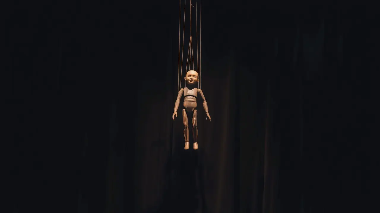 Sonhar com Marionete: Descubra os Significados Ocultos! Marionete suspensa por fios em palco escuro